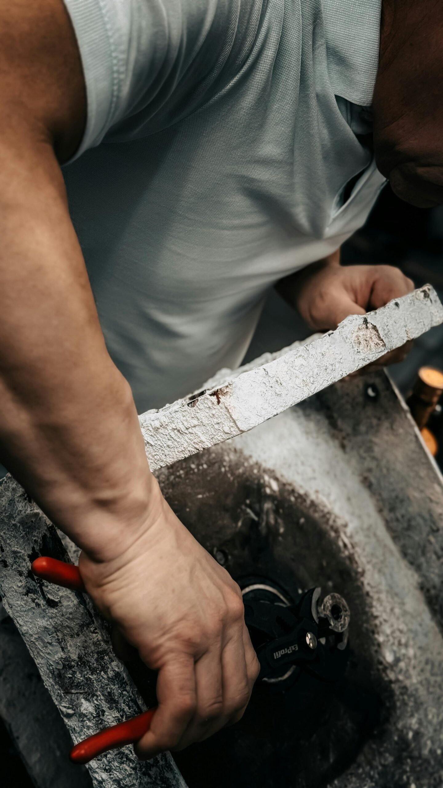 Craftsman skillfully repairing machinery with tools. Focus on hands and equipment.